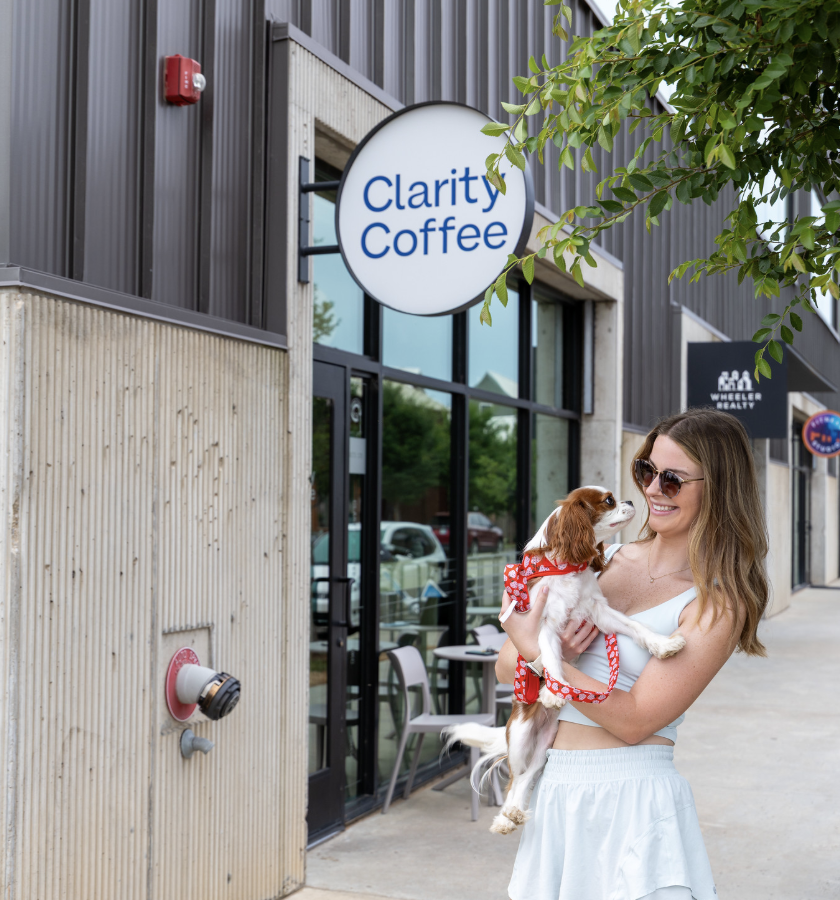 a woman holding a dog outside of a coffee shop at The  Lindy at Wheeler